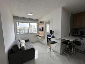 uma sala de estar com um sofá e uma cozinha em TrevizZo Allianz Parque em São Paulo