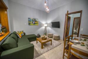a living room with a green couch and a table at Trikala Home in Tríkala