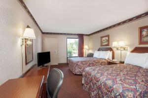 una camera d'albergo con due letti e una televisione di Days Inn by Wyndham Saint Pauls a Saint Pauls