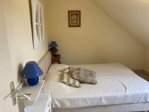 1 dormitorio con 1 cama con lámpara azul y mesa en Maisonnette 3 chambres - Plage de Belmont, en La Turballe