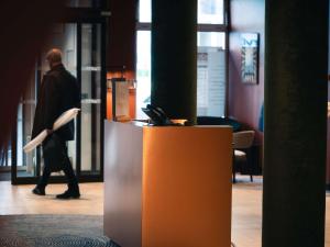 a man walking through an office with a desk at Novotel Lille Centre Grand Place in Lille