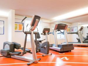 a gym with several tread machines in a room at Novotel Lille Centre Grand Place in Lille