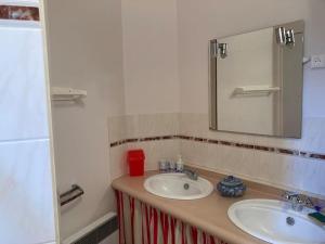 Un baño con dos lavabos y un espejo. en Maisonnette 3 chambres - Plage de Belmont, en La Turballe 9 fotos más