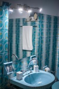 Trikala Home في تريكالا: حمام مع حوض أزرق ومرآة