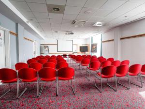 マルセイユにあるイビス マルセイユ セントル ガレ サン シャルルの赤い椅子とスクリーン付きの会議室