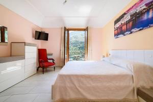 a bedroom with a large bed and a red chair at Casa vacanze Civale con Jacuzzi e parcheggio in Ravello