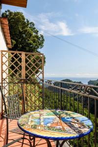 a table on a balcony with a view of the ocean at Casa vacanze Civale con Jacuzzi e parcheggio in Ravello