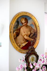 a clock hanging on a wall with a picture of a man at Hotel La Floridiana in Capri