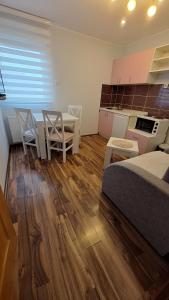 1 dormitorio con 1 cama, mesa y sillas en Apartments Katarina, en Zlatibor