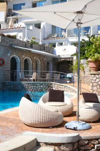 a pool with two lounge chairs and an umbrella at Hotel La Floridiana in Capri