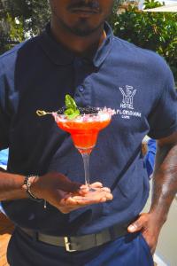 a man holding a drink in a martini glass at Hotel La Floridiana in Capri