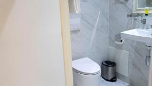 La salle de bains blanche est pourvue de toilettes et d'un lavabo. dans l'établissement A Hotels Glostrup, à Glostrup