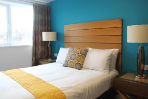 Maze apartments and rooms في هال: غرفة نوم بسرير مع جدار ازرق