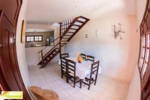 cocina y comedor con mesa y escaleras en Privê Maragogi Residence, en Maragogi