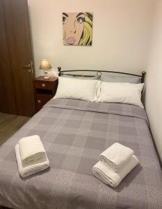 a bedroom with a bed with two towels on it at Helen's House in Tríkala