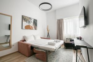 un soggiorno con letto e specchio di Elia Kolonaki Luxury Apartments ad Atene