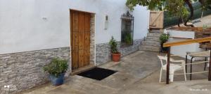 eine Terrasse mit Holztür und zwei Topfpflanzen in der Unterkunft Casa Rural CUARTELILLOS in Sabariego