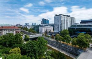 Blick auf eine Stadt mit Fluss und Gebäuden in der Unterkunft Hilton Vienna Park in Wien