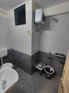 a bathroom with a white toilet and a sink at Gandhi Villa in Daman