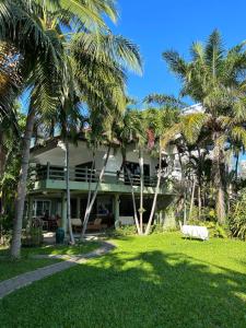 a house with palm trees in front of it at Baan Napapan Beach Front, Hua Hin in Hua Hin