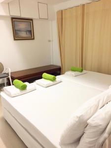 two beds in a room with green phones on them at Baan Napapan Beach Front, Hua Hin in Hua Hin