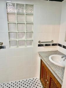 a bathroom with a sink and a window at Baan Napapan Beach Front, Hua Hin in Hua Hin