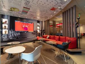 a living room with a couch and tables and a tv at ibis Lima Reducto Miraflores in Lima