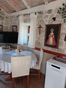 un comedor con una mesa y una cruz en la pared en Holiday Home Kamenice, en Gruda