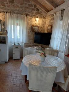 a dining room with a table and white chairs at Holiday Home Kamenice in Gruda