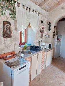 Gruda的住宿－Holiday Home Kamenice，厨房配有水槽和炉灶 顶部烤箱