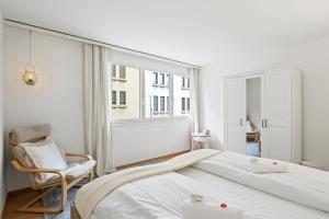 ein Schlafzimmer mit einem Bett, einem Stuhl und einem Fenster in der Unterkunft Bright, Central & Modern apartment in Luzern