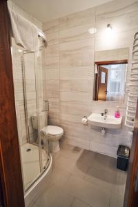 uma casa de banho com um lavatório, um WC e um chuveiro em Hotel Lilia em Włoszczowa