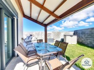 un patio con tavolo e sedie sul balcone. di Villa Clokassya - 60m² avec piscine - Saint-Pierre a Saint-Pierre