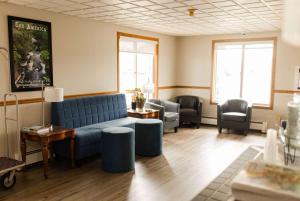a living room with a blue couch and chairs at Travelodge by Wyndham Escanaba in Escanaba