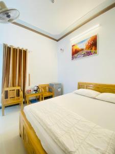 um quarto com uma grande cama branca num quarto em Hotel Aloha 2 em Ninh Hải