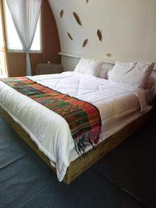 a bedroom with a large bed with white sheets at homestay noah in Likupang