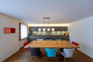 a dining room with a large wooden table and chairs at UnderDach in Andermatt