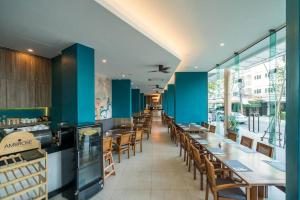 um restaurante com paredes azuis e mesas e cadeiras de madeira em Sea view apartment at Oceana by Lofty em Kamala Beach