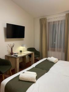 ホードメゼーヴァーシャールヘイにあるKenguru Panzióのベッド、デスク、テレビが備わるホテルルームです。