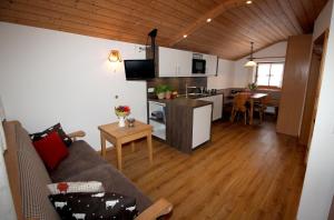 ein Wohnzimmer mit einem Sofa und einer Küche in der Unterkunft Schifterhof Ruhpolding in Ruhpolding