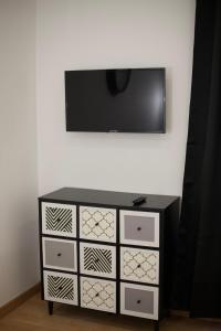 czarno-biała komoda z telewizorem na ścianie w obiekcie Apt 6 personnes terrasse vue parc w mieście Dunkierka