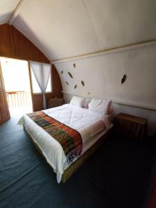 a bedroom with a large bed in a attic at homestay noah in Likupang