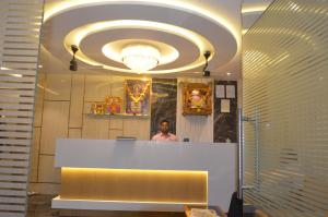 a man standing behind a counter in a room at Ritvik Residency in Navi Mumbai