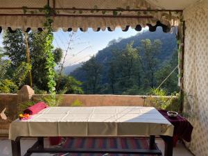 Una mesa en una habitación con vistas a la montaña en Shiv Shakti Yogpeeth Cottages, en Rishīkesh