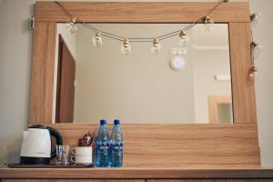 Un espejo en un estante con botellas. en Hotel Lilia en Włoszczowa