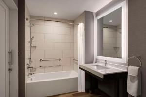 a bathroom with a sink and a tub and a mirror at Hyatt Place LAX/Century BLVD in Los Angeles