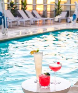 twee cocktails op een tafel naast een zwembad bij Hyatt Place LAX/Century BLVD in Los Angeles