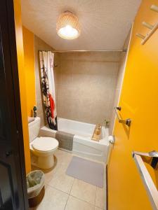 a bathroom with a tub and a toilet and a sink at Lu Yao Inn OP in Calgary