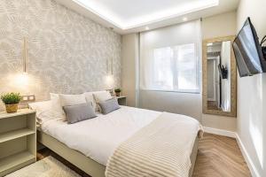 1 dormitorio con 1 cama blanca grande y espejo en Lovely apartment in Dama de Noche, en Marbella