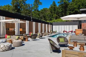 a patio with a pool with chairs and tables and a pool at Hotel Nyack, a JdV by Hyatt Hotel in Nyack